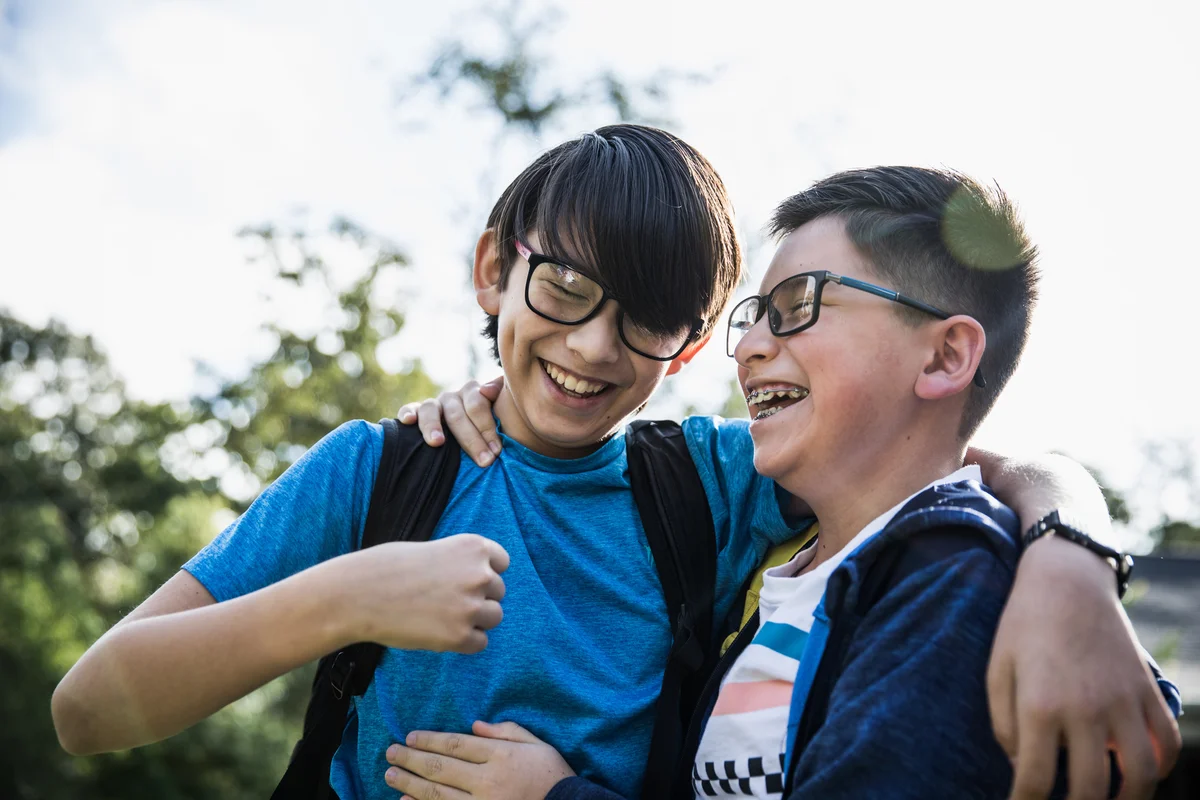School age cousins laughing outdoors