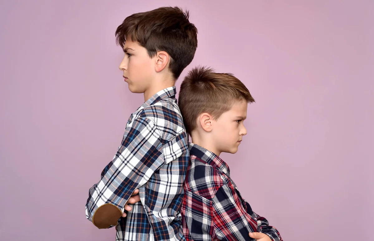 Two angry brothers standing back to back