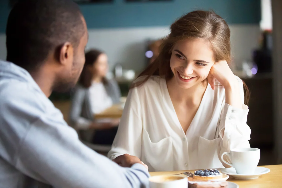 Couple flirting talking and holding hands in a cafe