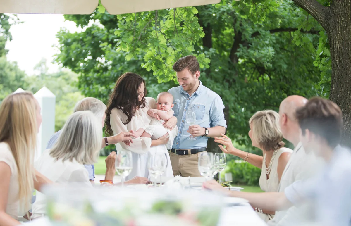 Baby being introduced to family on a garden party