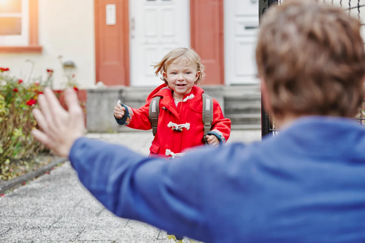 Happy daughter approaching father at house entrance