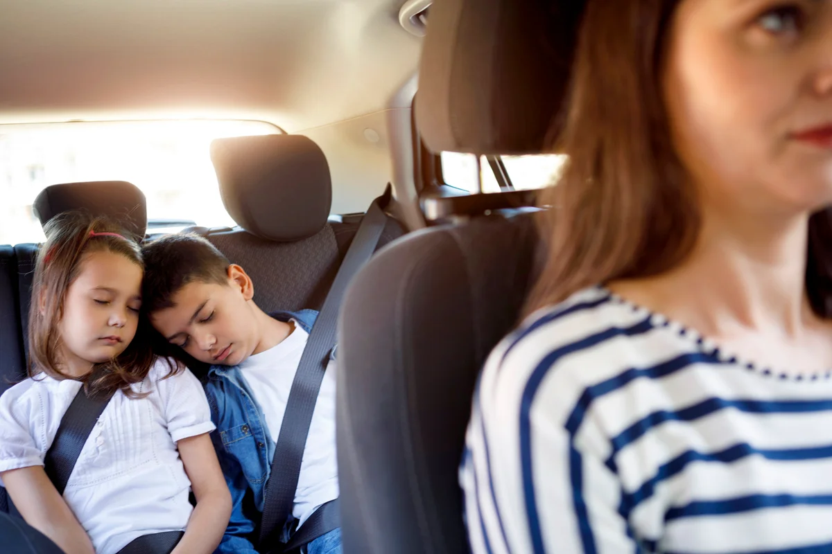Single mom driving and siblings sleeping in the car