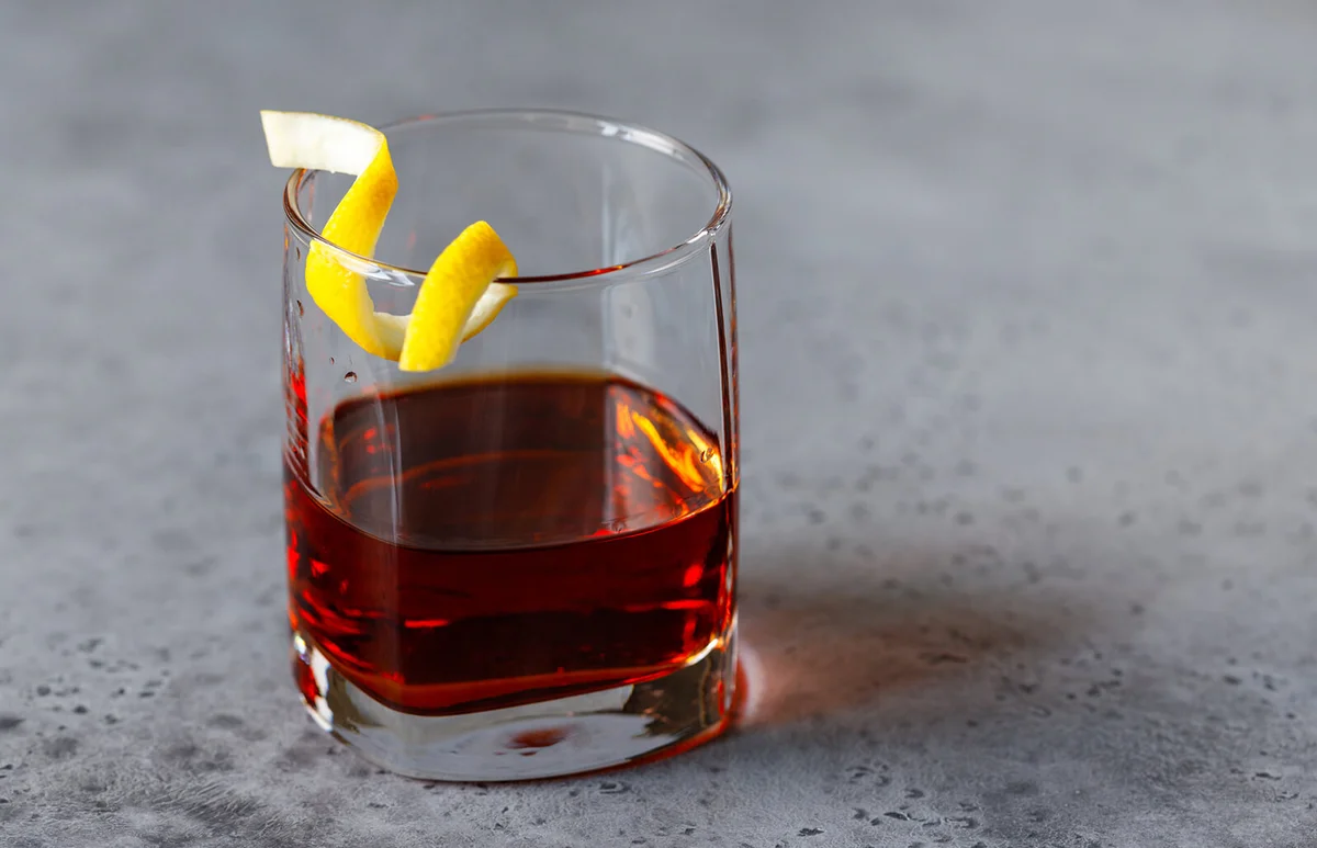 Cocktail with bitter and rye whiskey served lemon twist