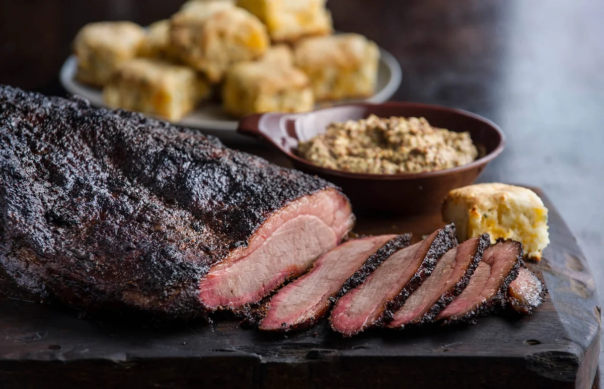 Sliced brisket and biscuits on cutting board