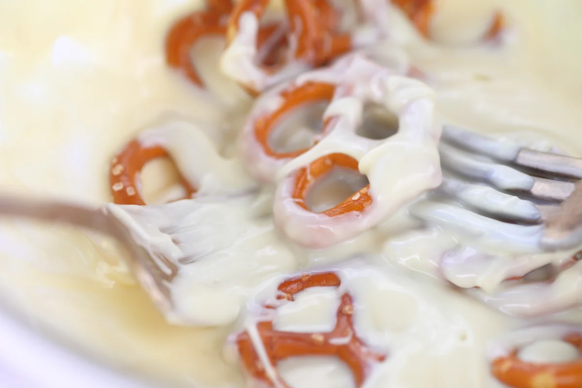 Dipping pretzels in melted white chocolate