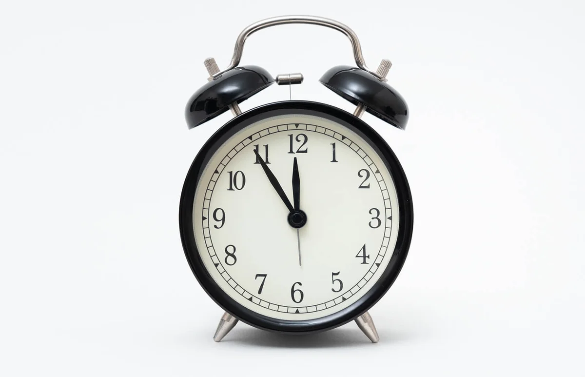 Retro alarm clock with five minutes to twelve o'clock