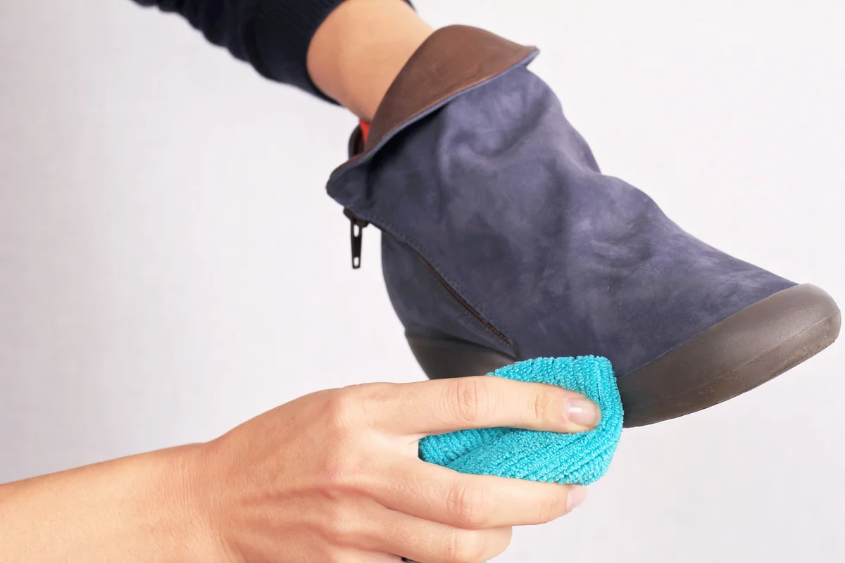 Woman cleaning Suede shoes, winter care.