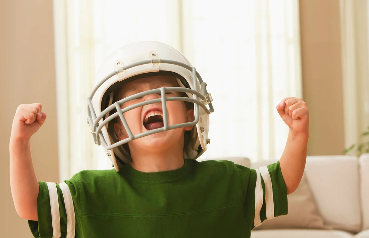 Cheering boy in football uniform
