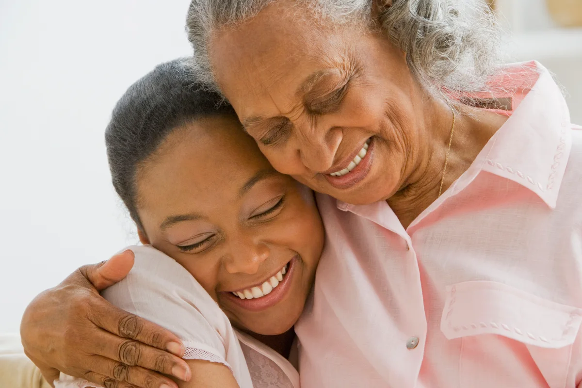 African grandmother and granddaughter hugging