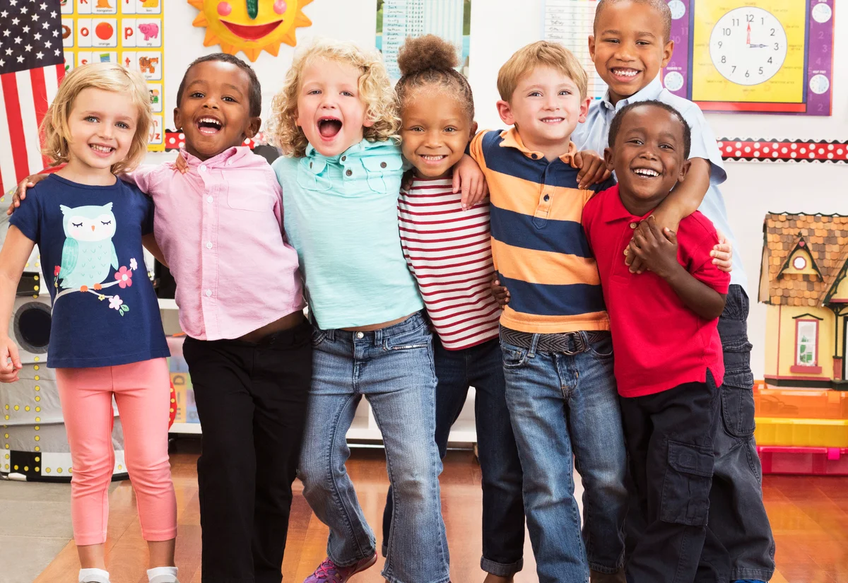 Portrait of smiling students hugging in classroom