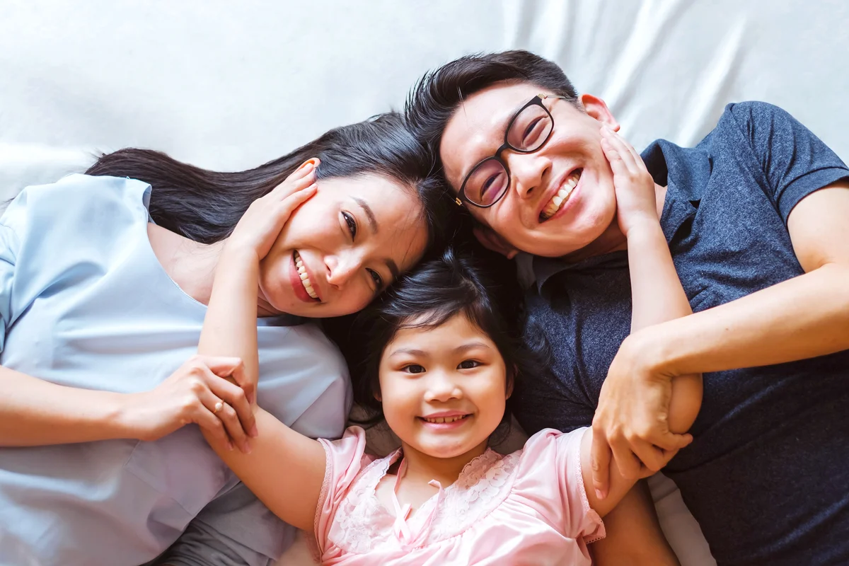 Happy family laying on bed in bedroom with happy and smile