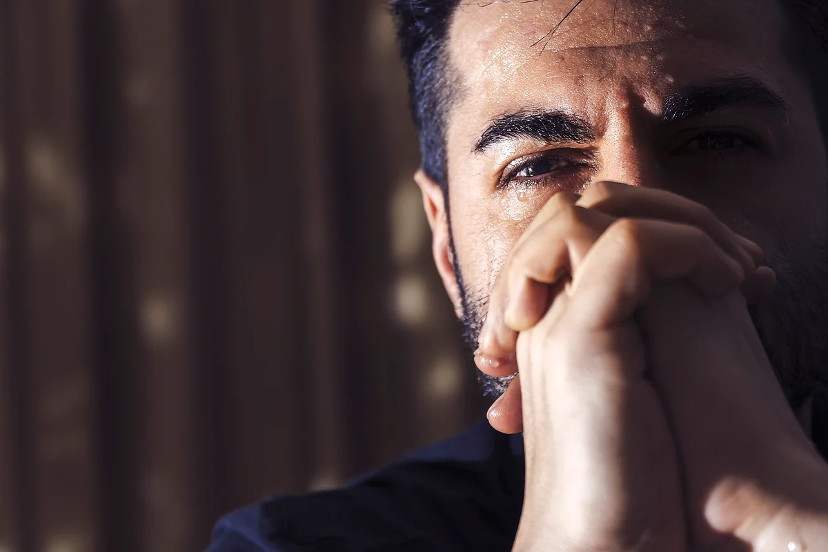 Depressed man praying and crying