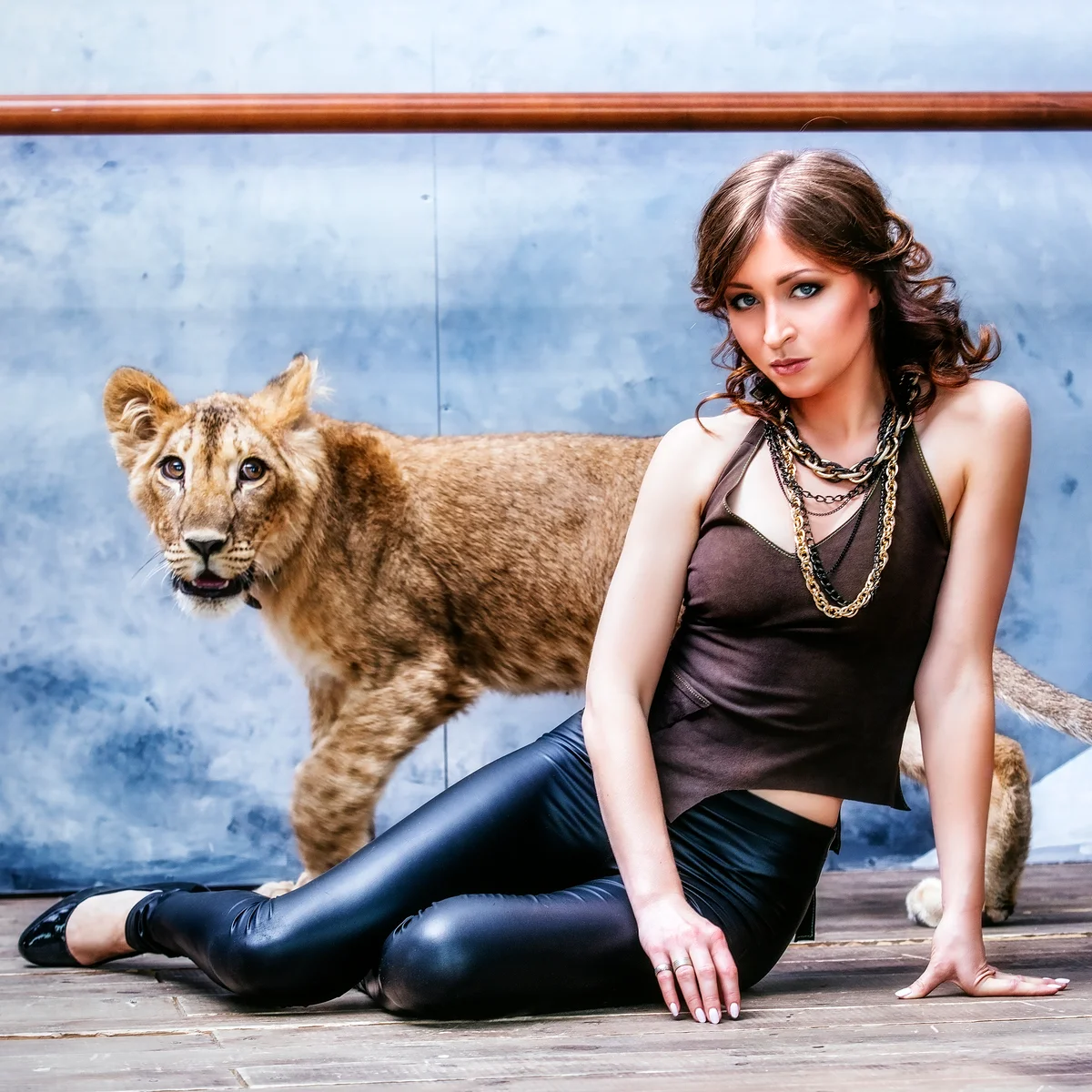 Fashionable young woman with a little lion cub