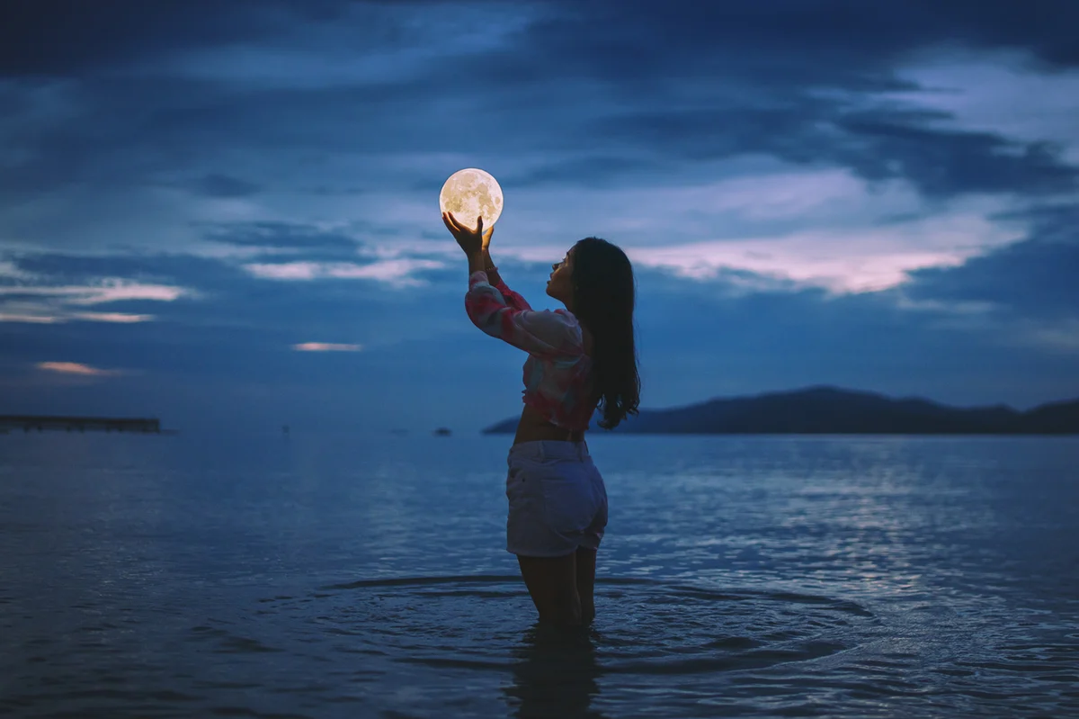 optical illusion of woman holding moon