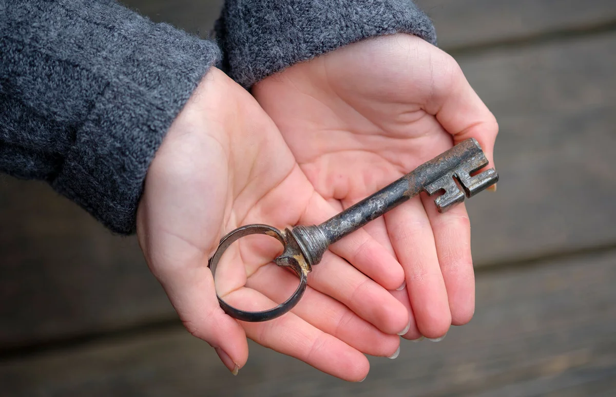 Hands holding an old key