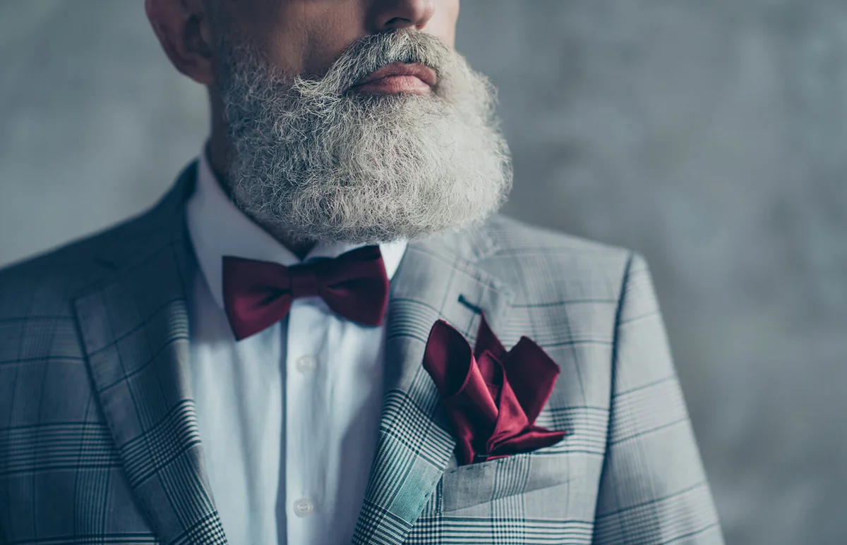 man wearing checkered grey jacket white shirt burgundy bow-tie