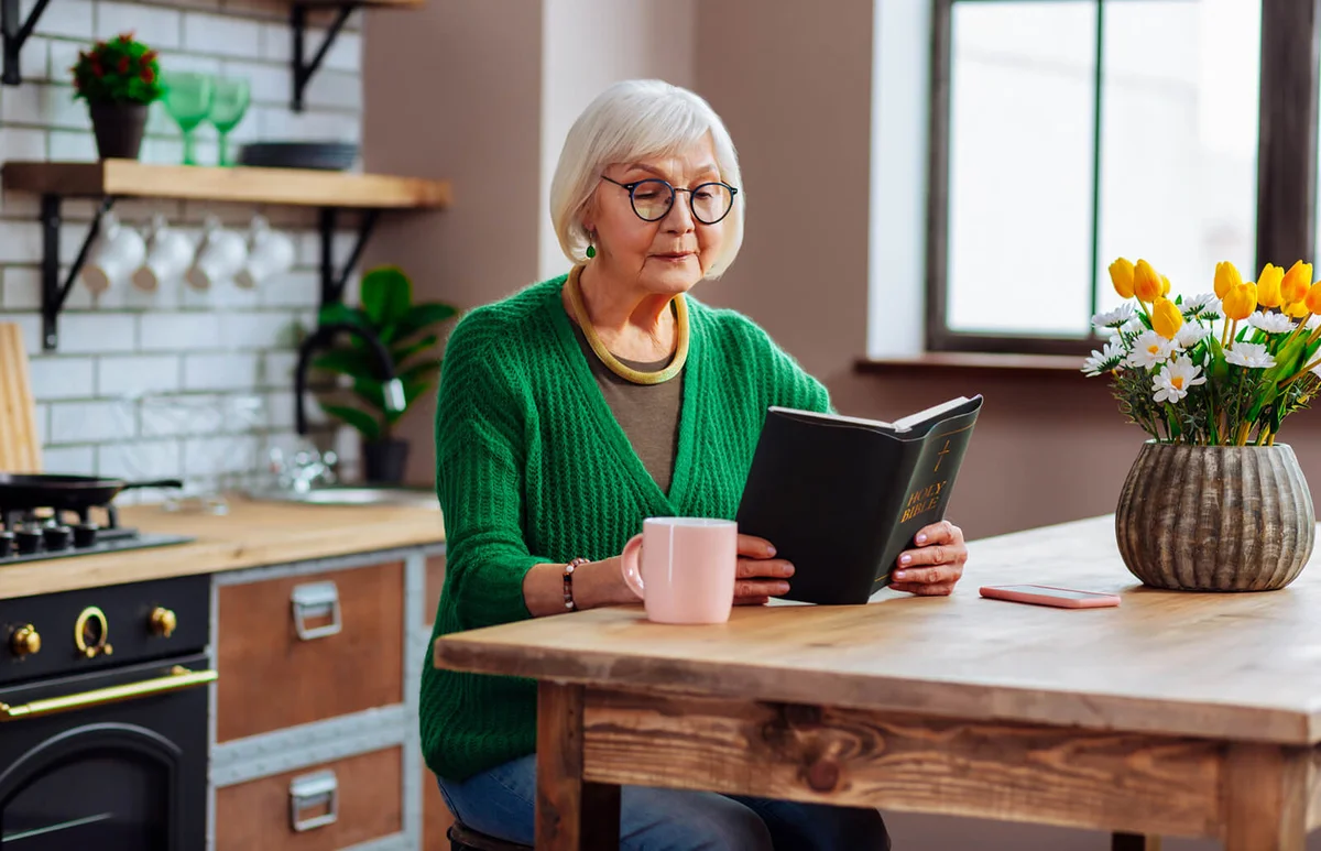 woman looking through Bible book