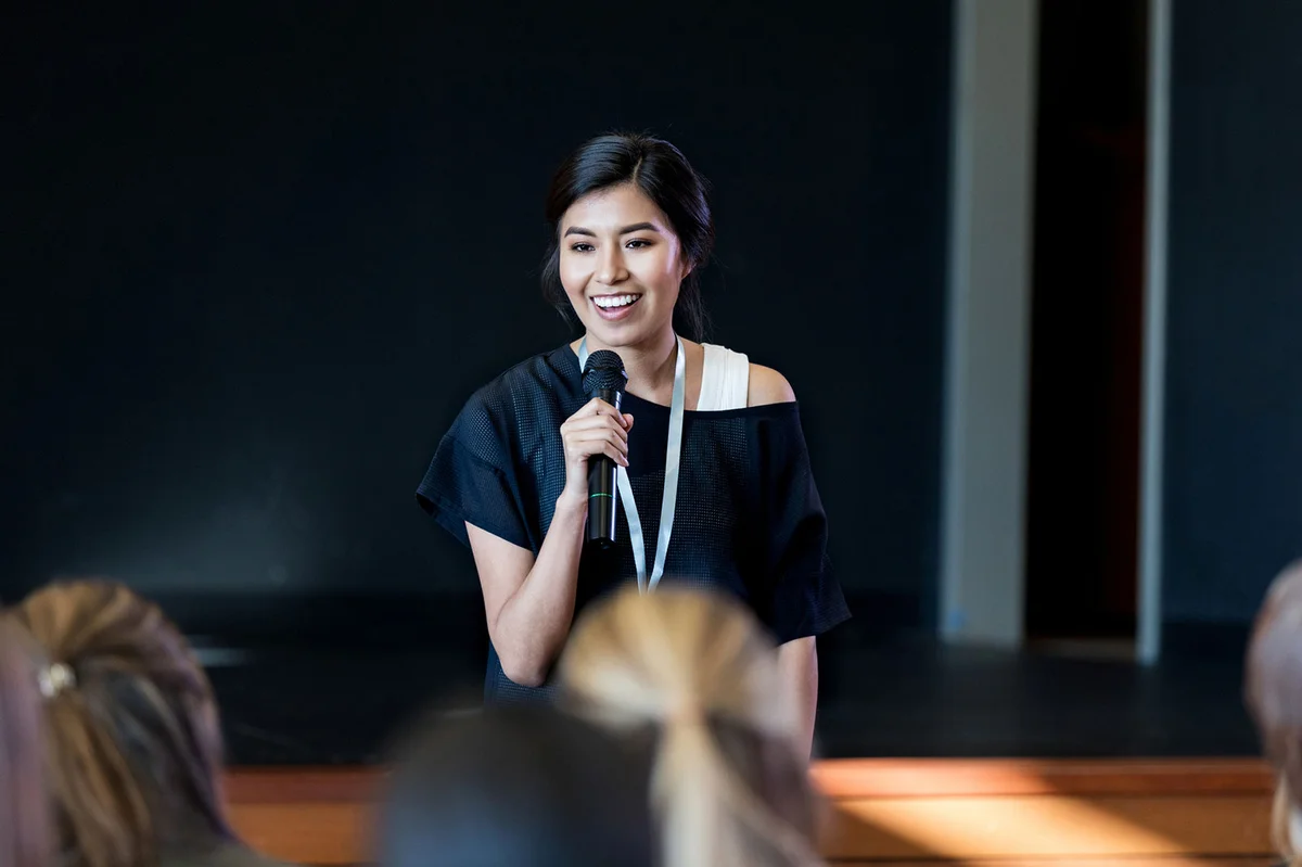 Woman speaks with crowd during seminar