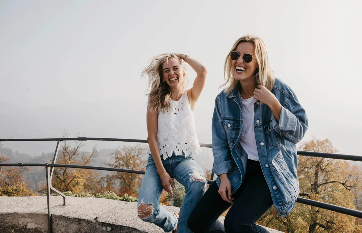 two happy young women sitting on railing at Sausenburg Castle