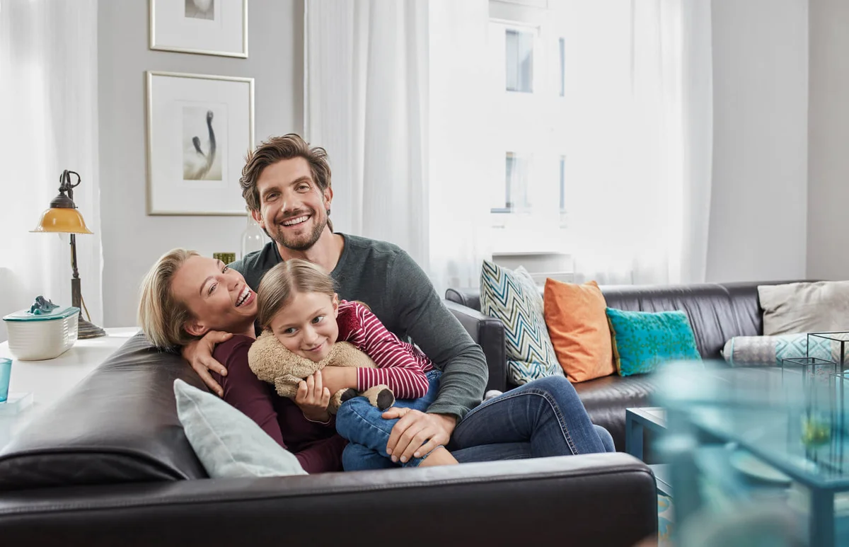 Portrait of happy family sitting on couch at home