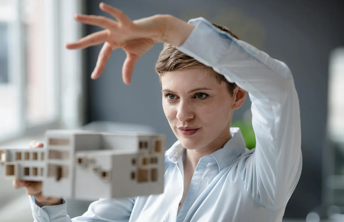 Confident businesswoman holding architectural model in office