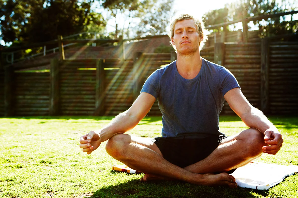 Young man meditating outdoors