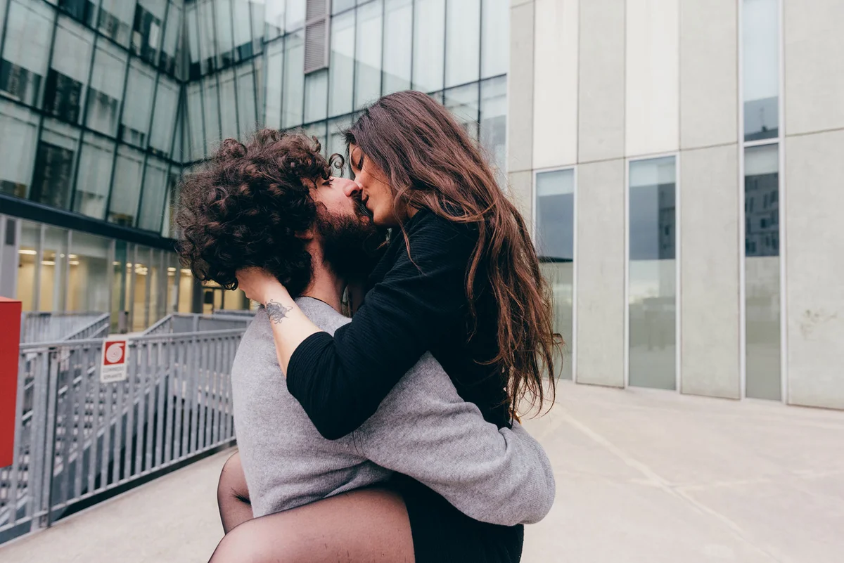 Passionate couple embracing and kissing outdoors