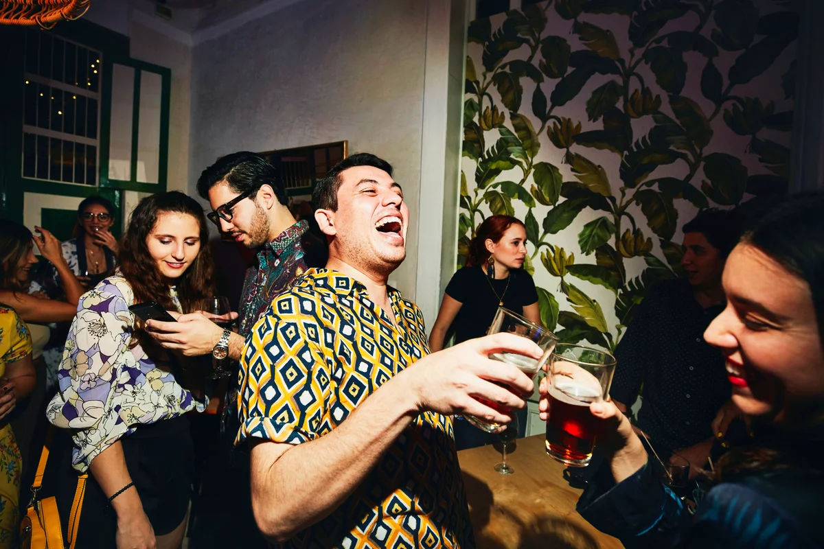 Laughing friends toasting during party in night club