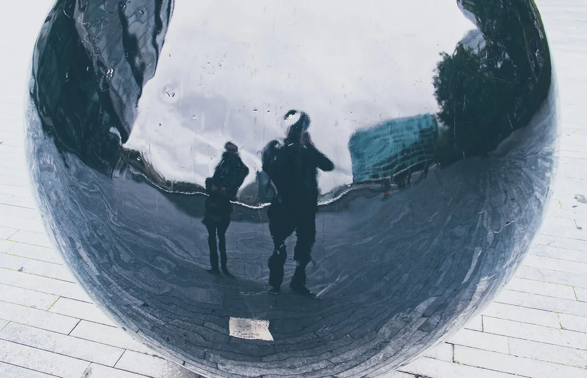 distorted reflection of two people
