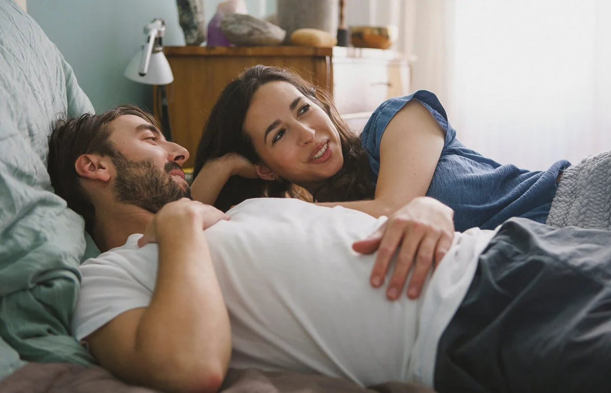 Couple relaxing and talking on bed