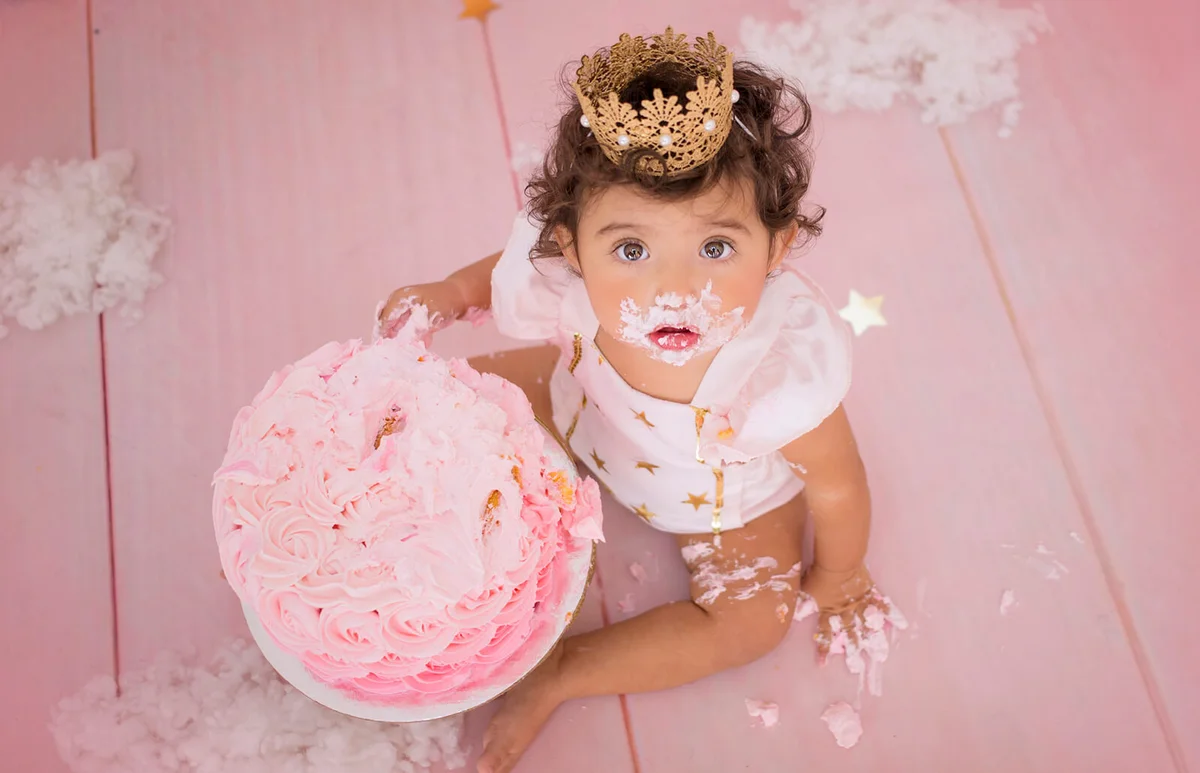 Cute Baby Girl With Birthday Cake Sitting At Home