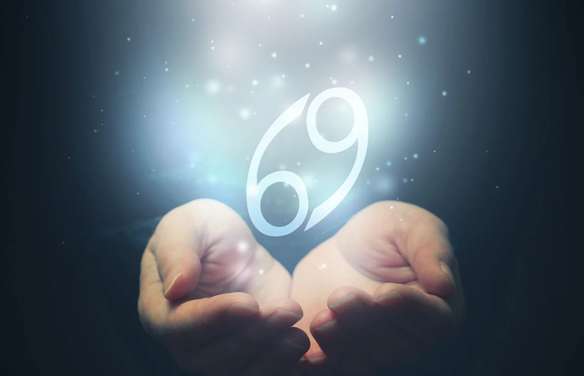 hands holding zodiac sign for Cancer