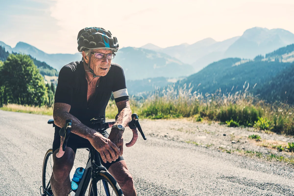 Senior man resting on mountain bike trail