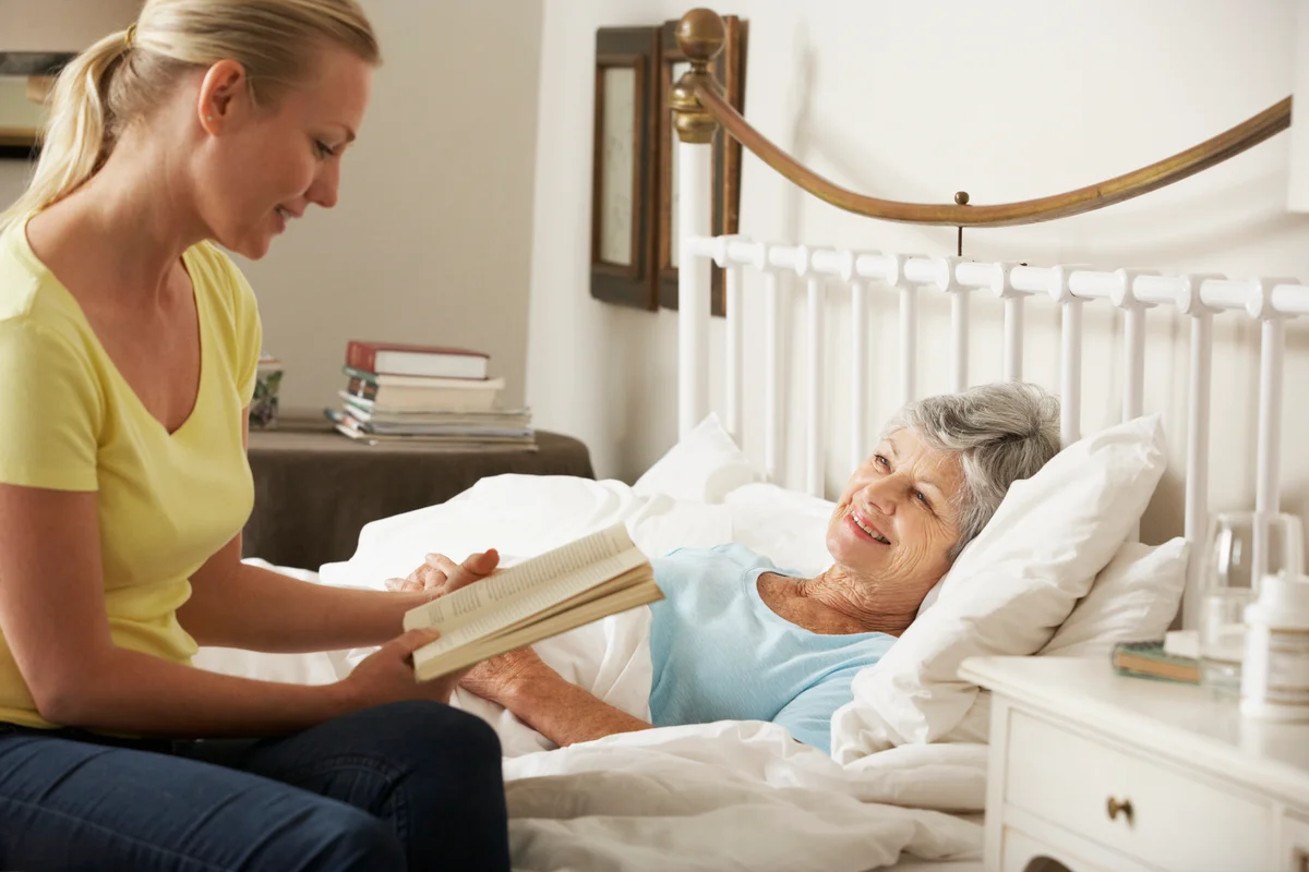 Woman reading to hospice patient