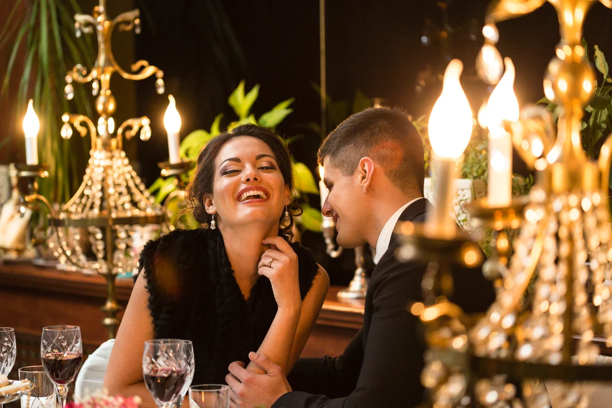 Woman laughing with man during dinner date