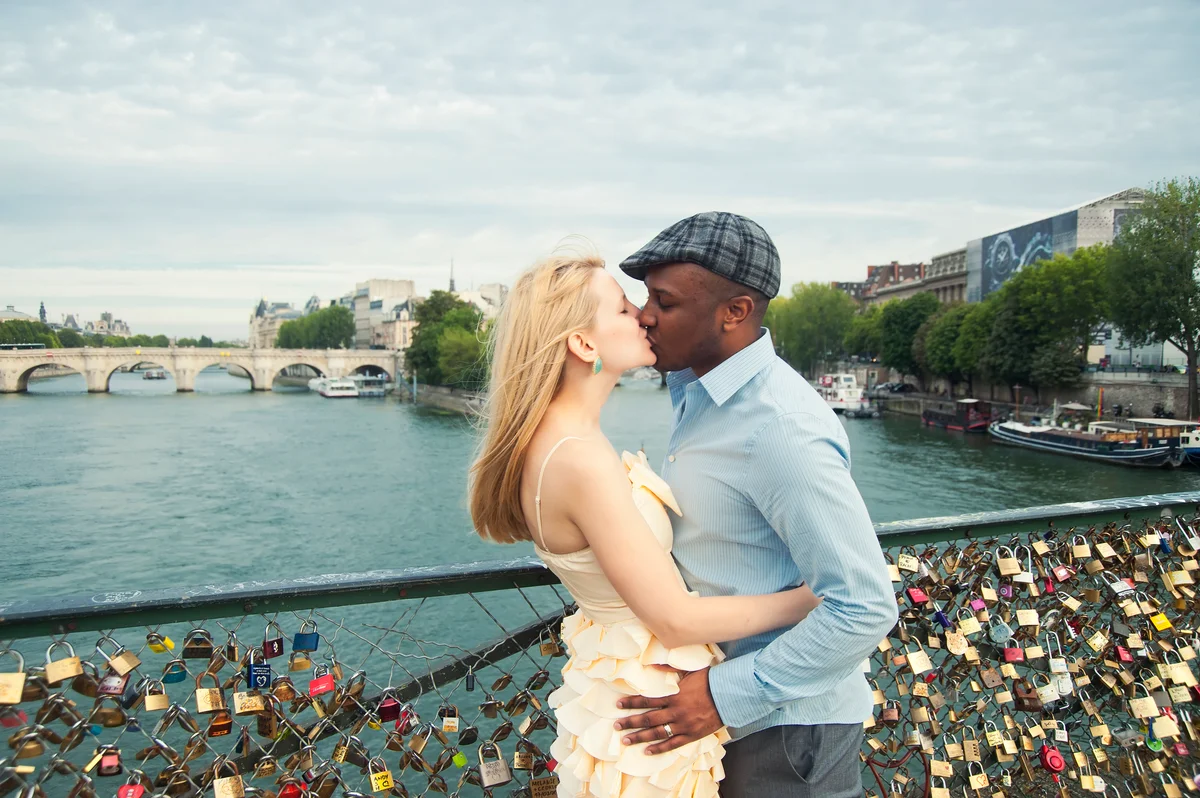 Young couple kissing by Pont des Art, Paris, France