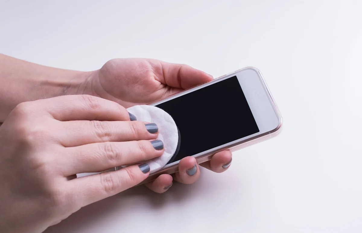 Woman hand cleaning mobile phone display