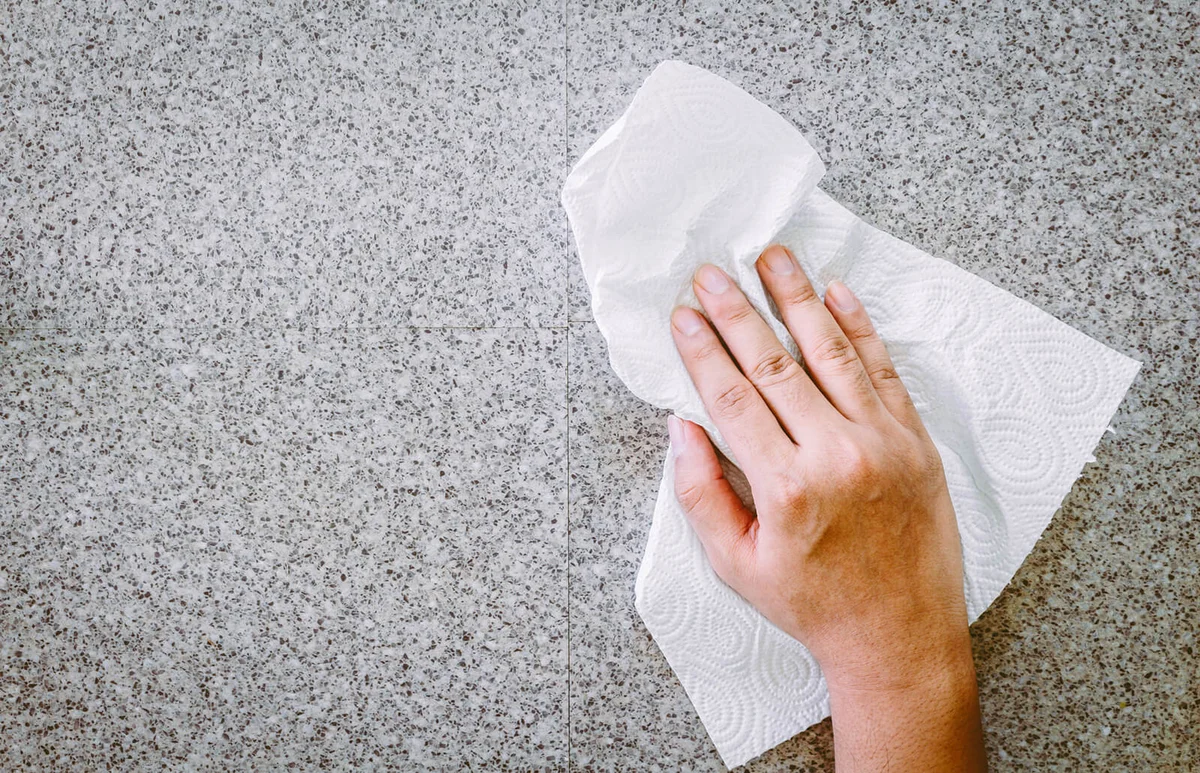 Cropped Hand Cleaning Floor With Tissue Paper