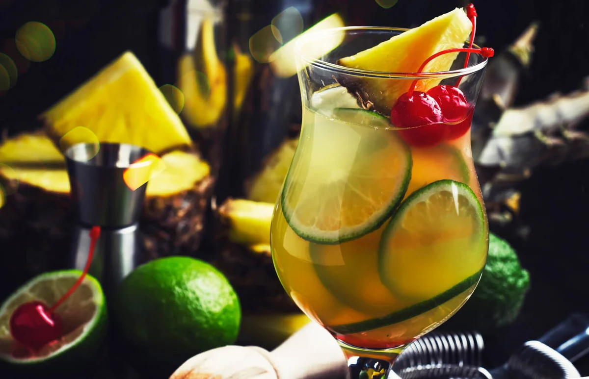 Summer exotic punch cocktail with pineapple juice, lime, ice and vodka