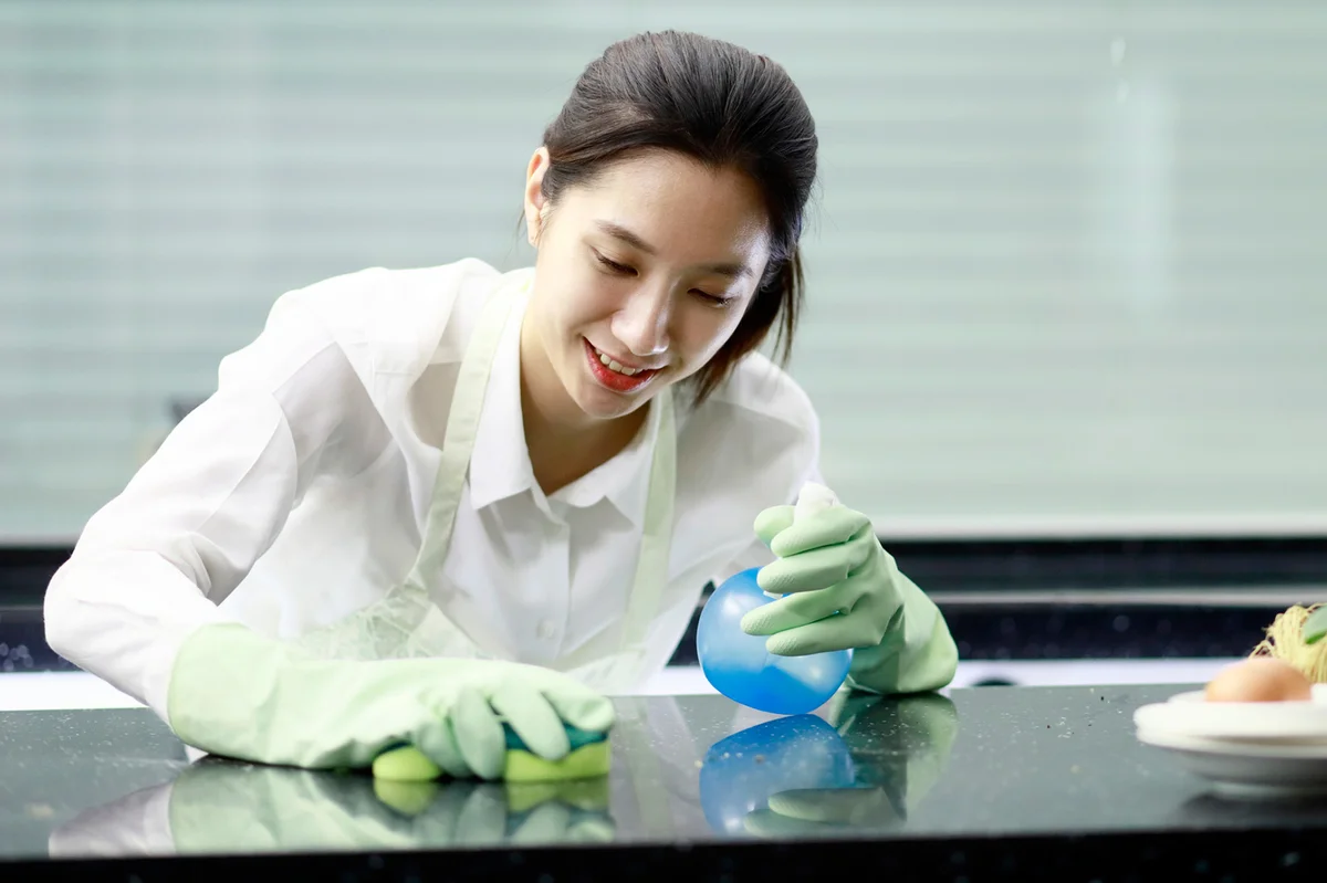 Woman disinfecting counter with bleach solution