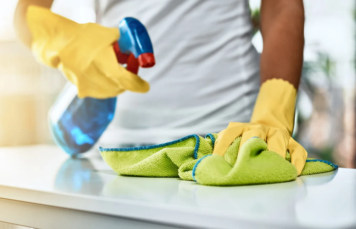 Shot of an unrecognizable woman cleaning a table at home
