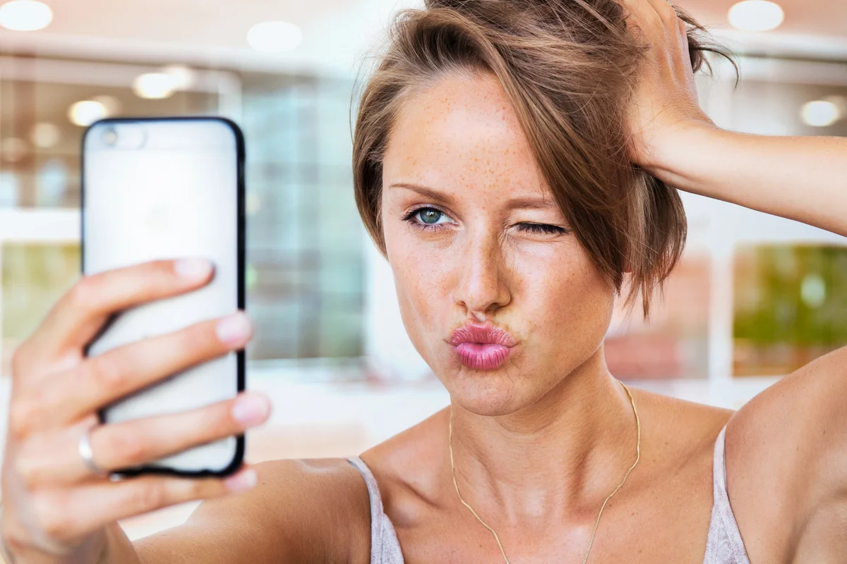 Vain woman looking at herself in mirror