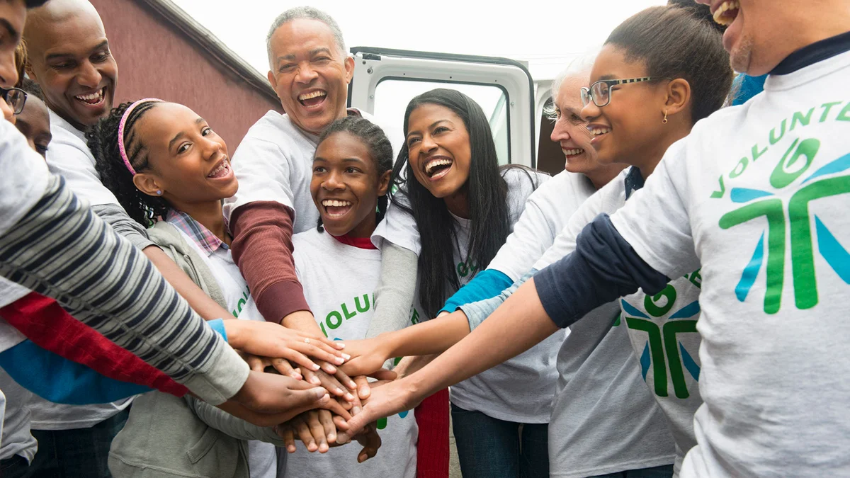 Volunteers stacking hands and cheering