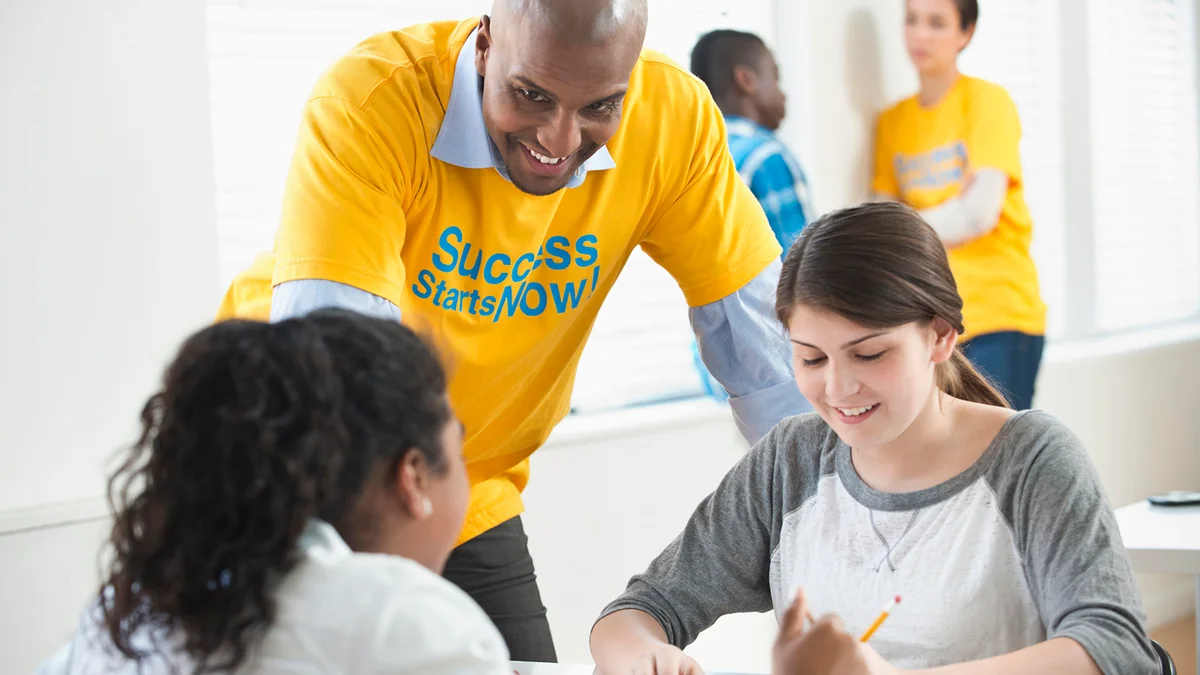 Volunteer mentor helping students with homework