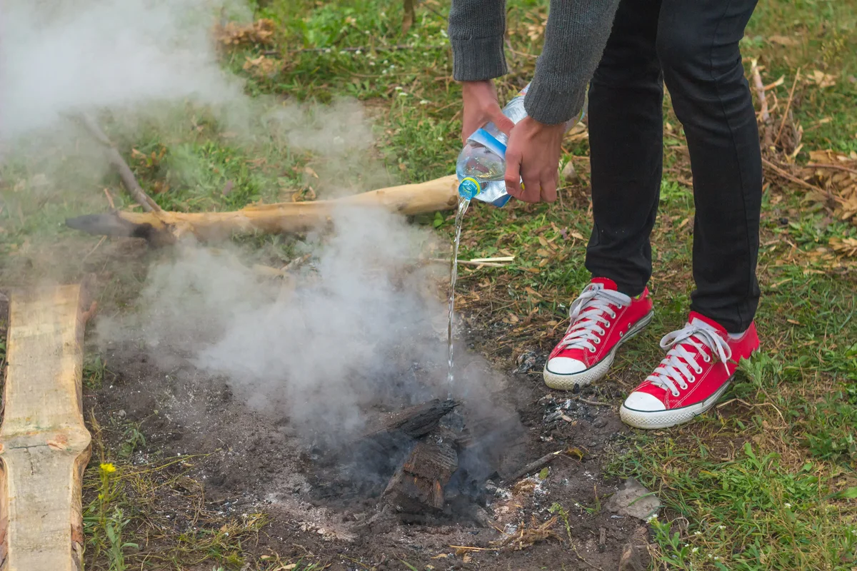 Pouring water onto campfire