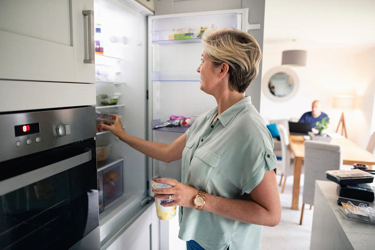 Woman putting food in refrigerator