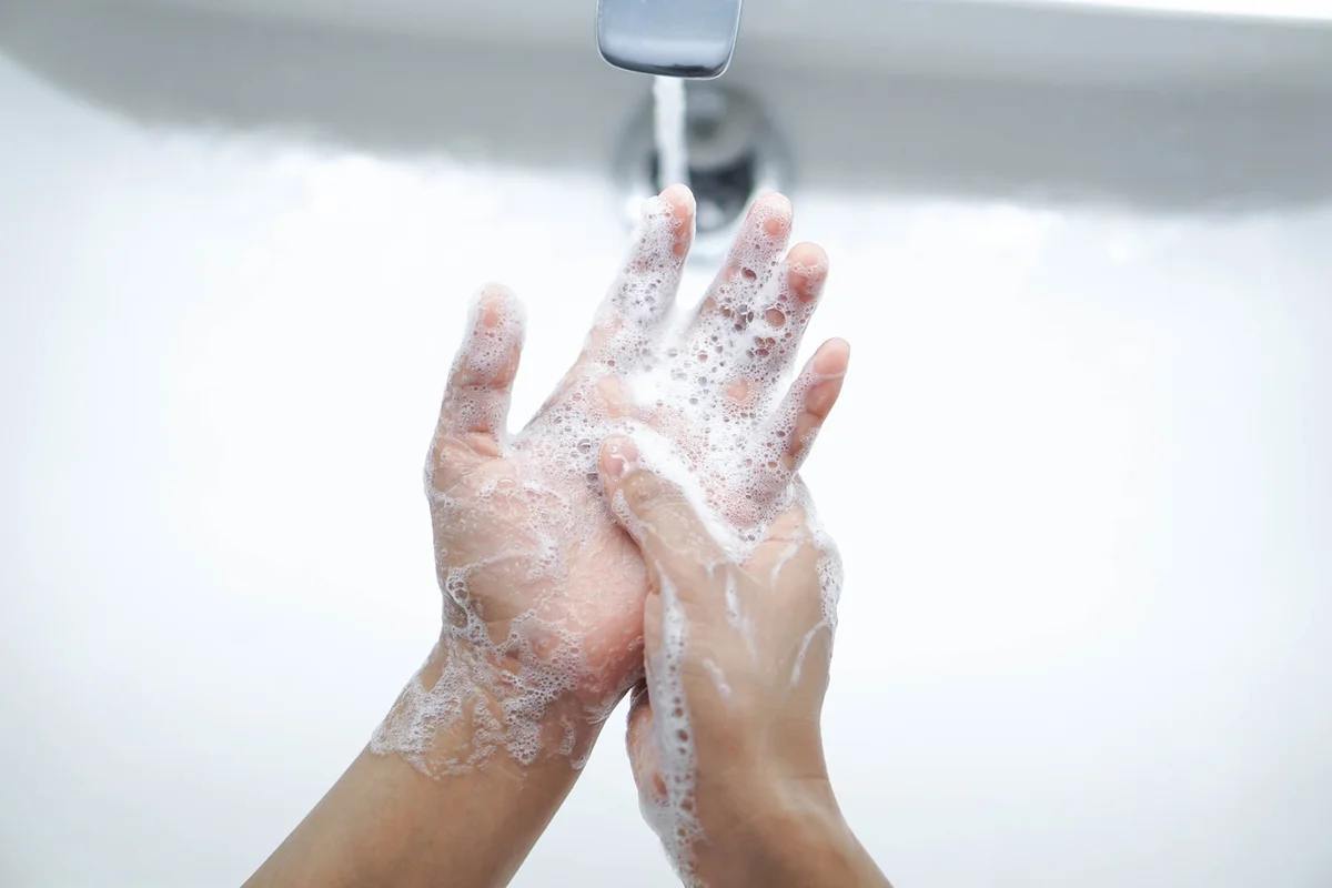 Person washing hands with soap