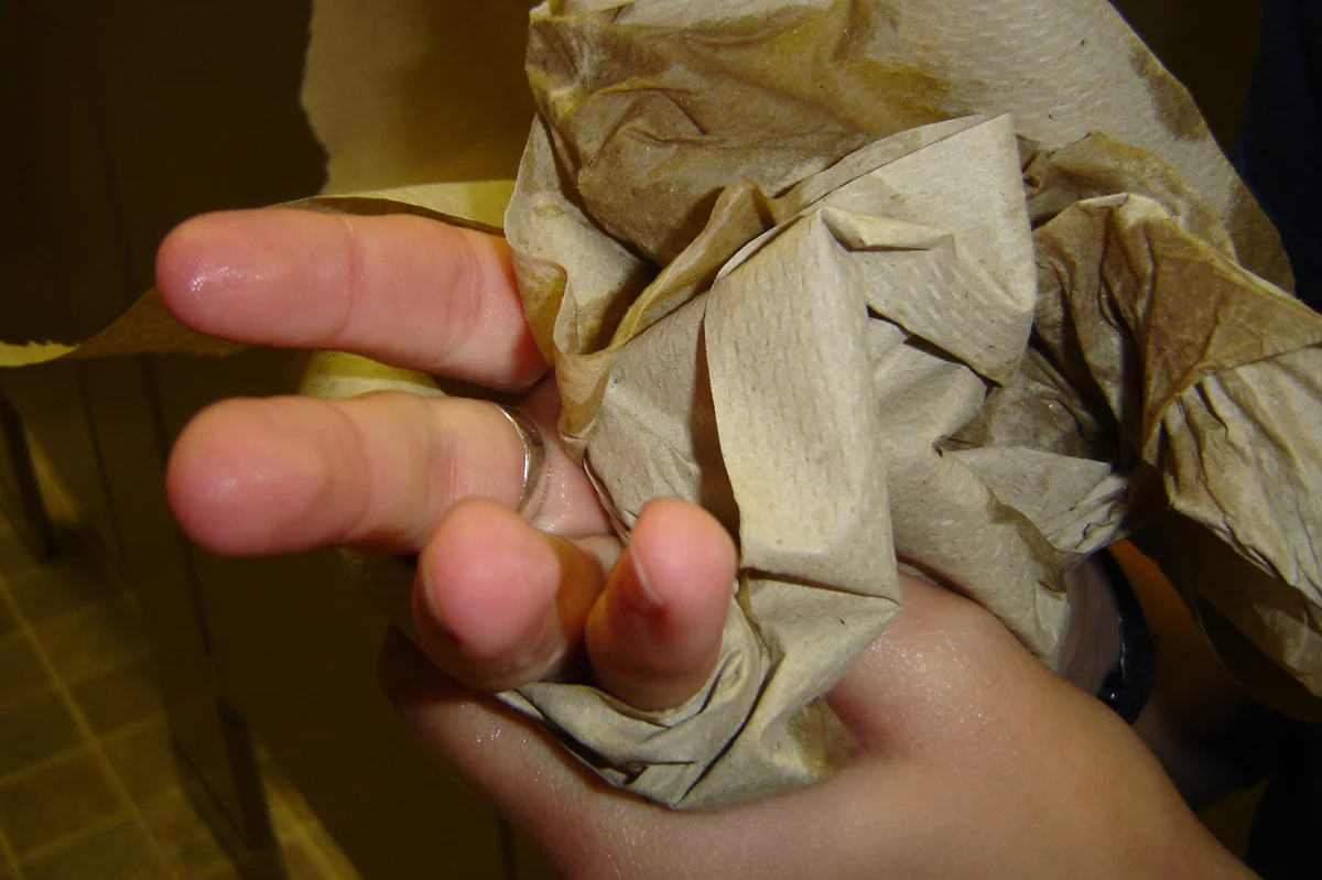 Person drying hands with paper towels
