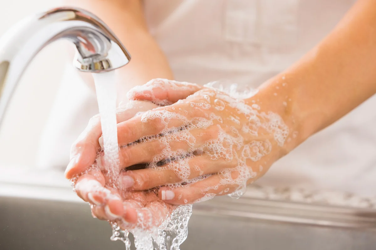 Person rinsing soap off hands