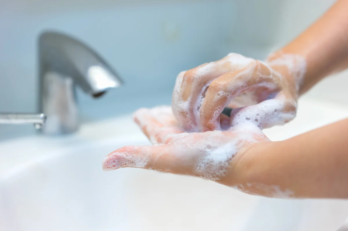 Person scrubbing nails with soap